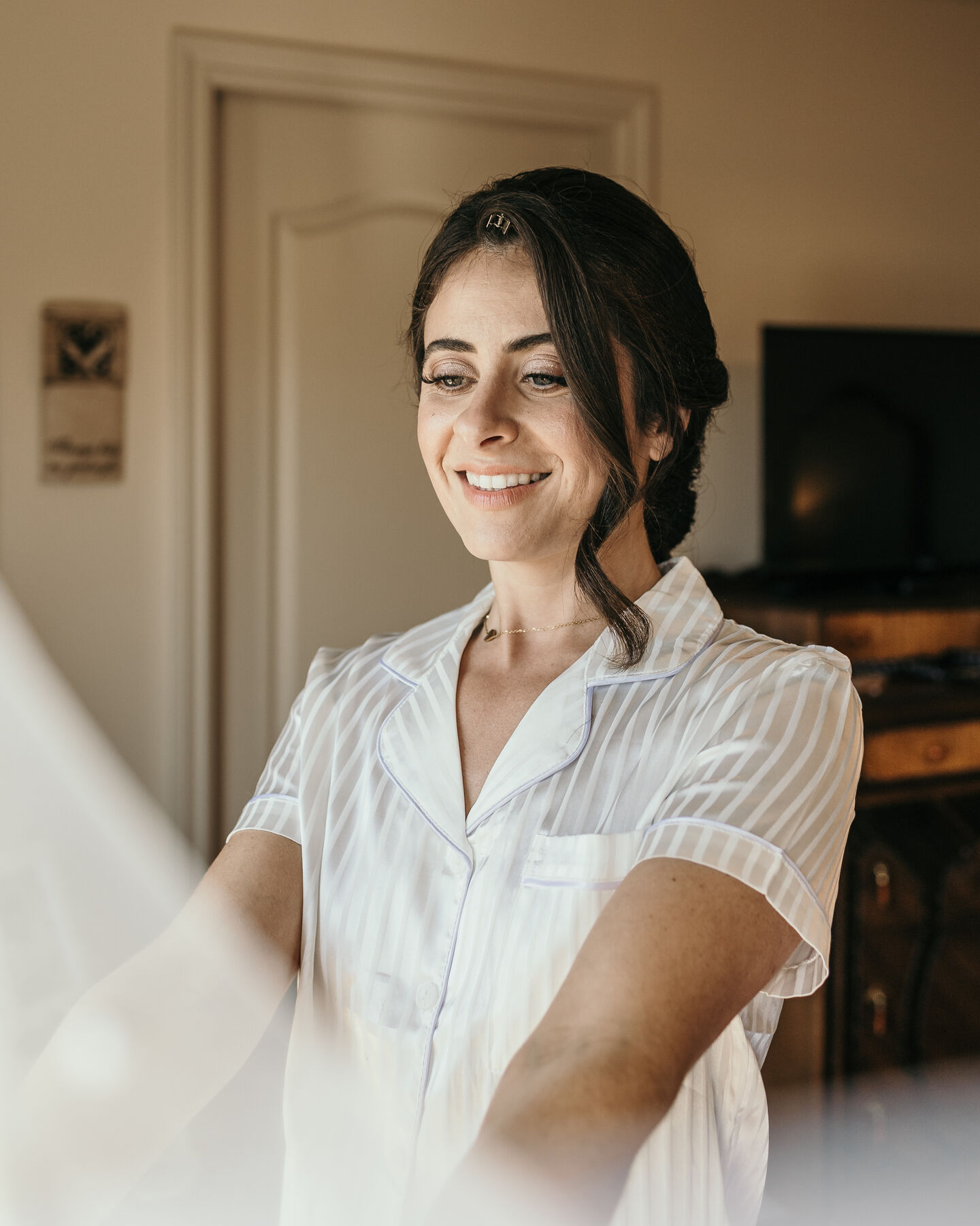 Bride in pyjamas smiling as she looks off to the side